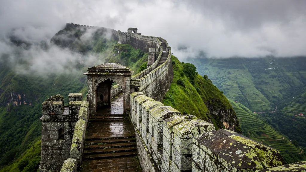 Historic Lohagad Fort with stone walls enveloped in monsoon mist