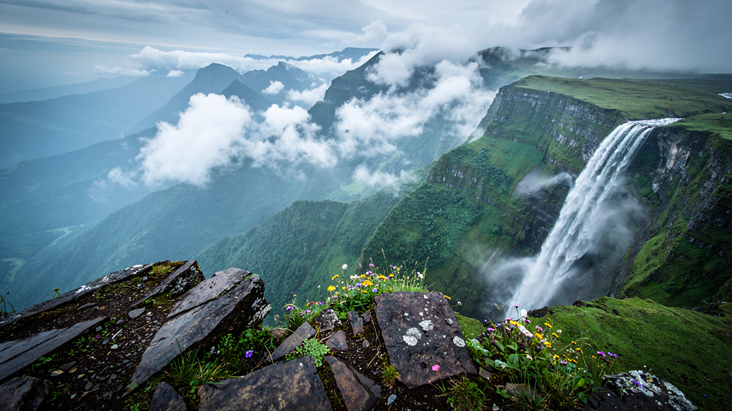 Tigers Leap cliff edge with waterfall and misty valleys